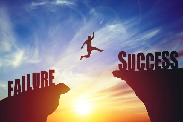 Silhouette of business man jump to success text over a beautiful high view mountain background